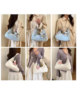 Détail du sac à bandoulière hobo plissé avec un adorable pendentif en forme d'ours