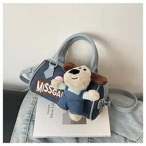 Detail of dark blue denim Boston bag with dog plush charm and MISSGAV embroidery