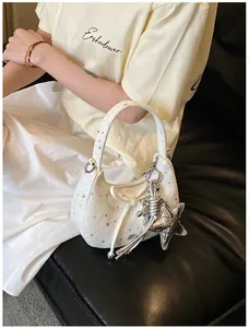 Detail van witte tas met sterrenprint, strik en metalen hangers in lifestyle-scène