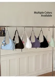 Détail de sacs croissants plissés multicolores avec bandoulières tressées et charms