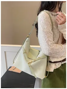 Lichtgroene draagtas van olie-wasleer gedragen door een model in een minimalistisch café