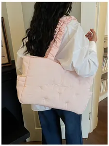 Pink quilted nylon tote bag with ruffle strap and delicate bow embroidery detail