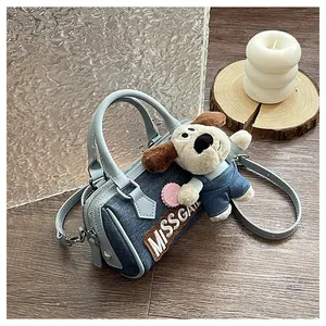 Detailed side view of mini Boston bag with denim patchwork and plush dog charm