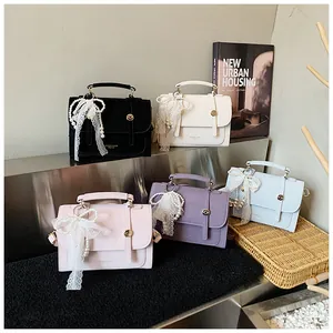 Detail of square handbags with lace pearl handles and magnetic closure in multiple colors