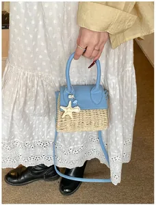 Detail of light blue leather and woven straw mini bag with a starfish charm and strap