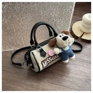 Detail of canvas Boston bag with leather handles and cute plush puppy keychain accessory