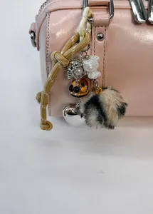Detailed charm pendant with plush ball, mini resin cat and metal heart on pink pillow bag