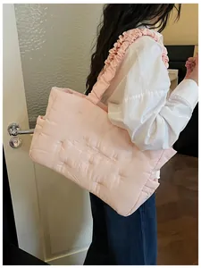 Pink quilted nylon tote with ruffle strap detail and floral embroidery accent