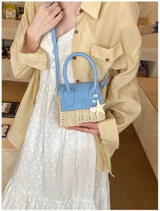 Mini straw handbag in sky blue leather trim featuring starfish charms on female model