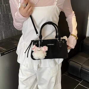 Large black bucket bag with plush bear charm and adjustable shoulder strap for daily commuting