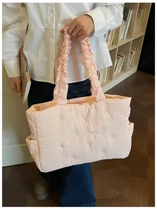 Close-up of pink quilted tote bag with bow embroidery and ruffled handle detailing