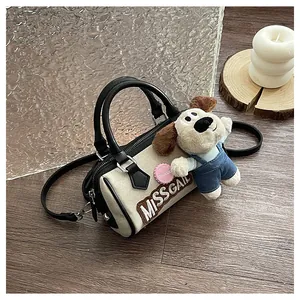Detail of canvas Boston bag featuring Miss Gail lettering and a cute plush dog pendant