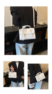 Close-up of white crossbody bag featuring elegant lace bow and pearl handle charms