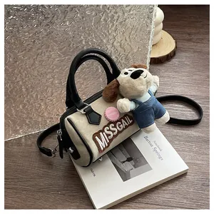 Detail of Boston bag with embroidered logo and cute plush puppy charm accessory