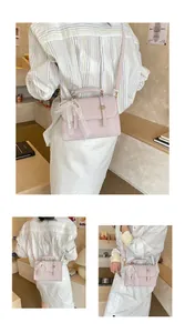 Detail of light pink square handbag featuring lace bow and pearl charm on the handle