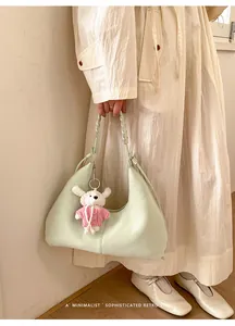 Détail du sac croissant vert clair en PU avec anse tressée et charm chien