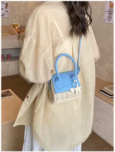 Detail showing woven straw texture and light blue leather flap with starfish charms