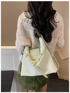 Achteraanzicht van model met een grote beige en groene leer tote rugzaktas