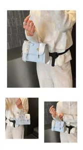 Detail of light blue leather handbag with lace trim, pearl charms, and gold hardware