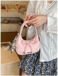 Detail van roze handtas met strik, zilveren sterhanger en verfijnd sterpatroon