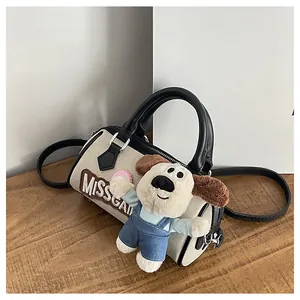 Detail of canvas Boston bag with leather handles and cute plush puppy keychain