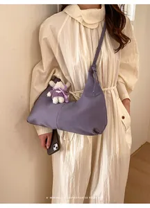 Détail du sac à main violet lilas avec pendentif lapin mignon porté par un modèle
