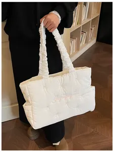 Detail of white quilted nylon tote with pink bow embroidery and ruffled handles