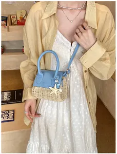 Close-up of mini straw crossbody bag with sky blue leather lid and sea charms