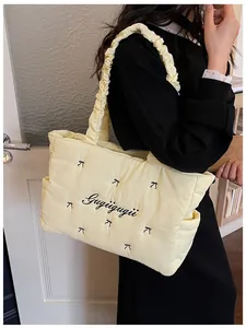 Macro shot of quilted nylon tote with butterfly embroidery and ruffled shoulder strap