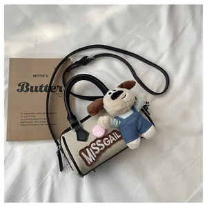 Close-up of beige canvas Boston bag with dog plush charm and MISSGAIL embroidery