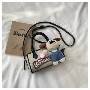 Detail of canvas Boston bag with plush puppy pendant and Missgail embroidery