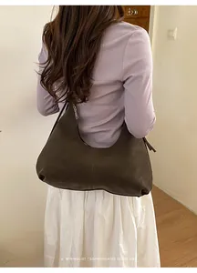 Vue arrière d'un mannequin portant un sac hobo rétro marron foncé au style épuré