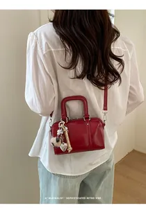 Detailed back view of a red retro Boston bag with plush ball and heart charms