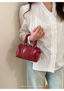 Detail of red leather mini Boston bag with silver hardware and chic grab handles