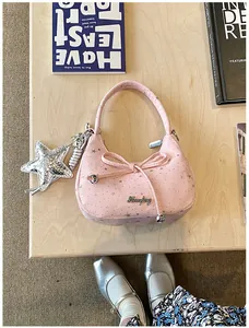 Detail van roze stoffen tas met zilveren sterren, strik en glitter ster hanger