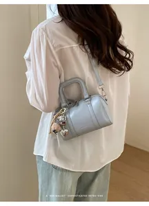 Light blue Boston pillow bag with charms shown from a back view on a model