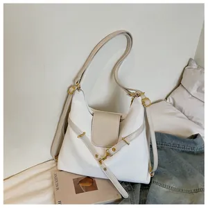 Detail van een witte oliewas lederen shopper met beige klep en gouden metalen gesp