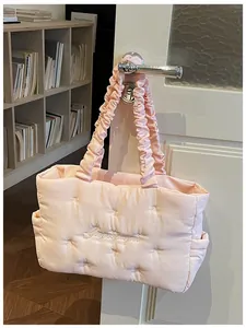 Detail showing the ruffled handle and quilted texture of a pink nylon tote bag