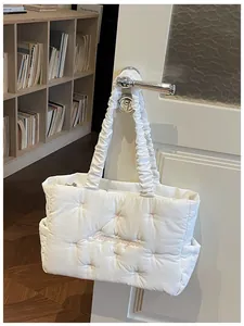 Detail of white quilted nylon tote bag with pink embroidery and ruched handles