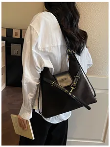 Detail van vintage zwarte leren tas met metalen oogjes op de riem en gegraveerd logo
