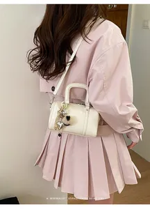 Detailed back view of a cream glossy pillow bag styled with a minimalist outfit