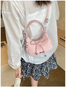Detail van roze crossbodytas met strik, sterrenprint en berenhanger gedragen door model