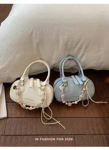 Detail of minimalist leather handbags with beaded tassels in cream white and light blue