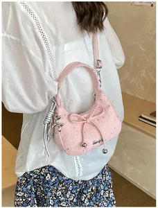 Detail van roze halvemaanvormige tas met zilveren sterren en een decoratieve strik