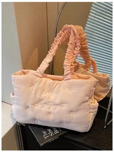 Detail of light pink quilted cloud tote bag with bow embroidery and ruffled handle