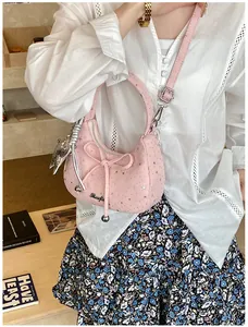 Detail van roze hobo tas met zilveren sterpatronen en een decoratieve strik erop