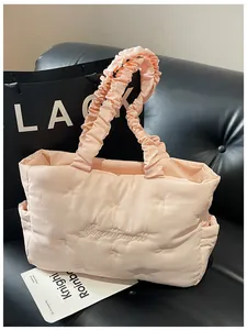 Detail of pink quilted nylon tote with bow stitching and soft ruched cloud handle