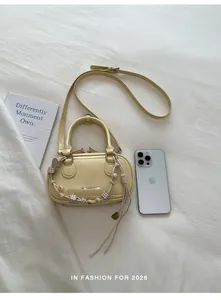 Top view of yellow crossbody bag with woven details and beads on white fabric