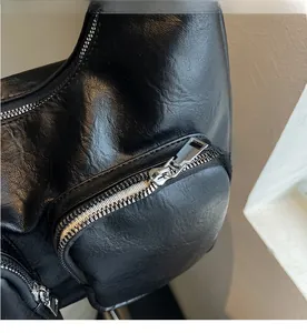 Detailed macro view of high-quality smooth silver metal zipper on black leather handbag
