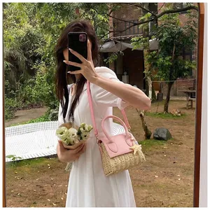 Pink leather handle and starfish charm detail on mini woven straw crossbody summer bag